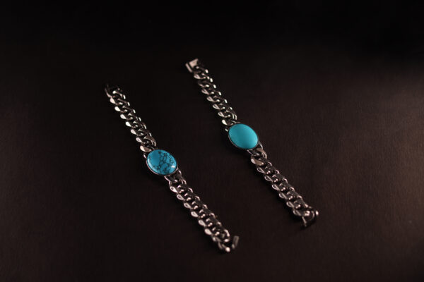 Stunning silver Cuban link bracelet featuring a vibrant oval turquoise gemstone centrepiece, laid on a dark matte background.